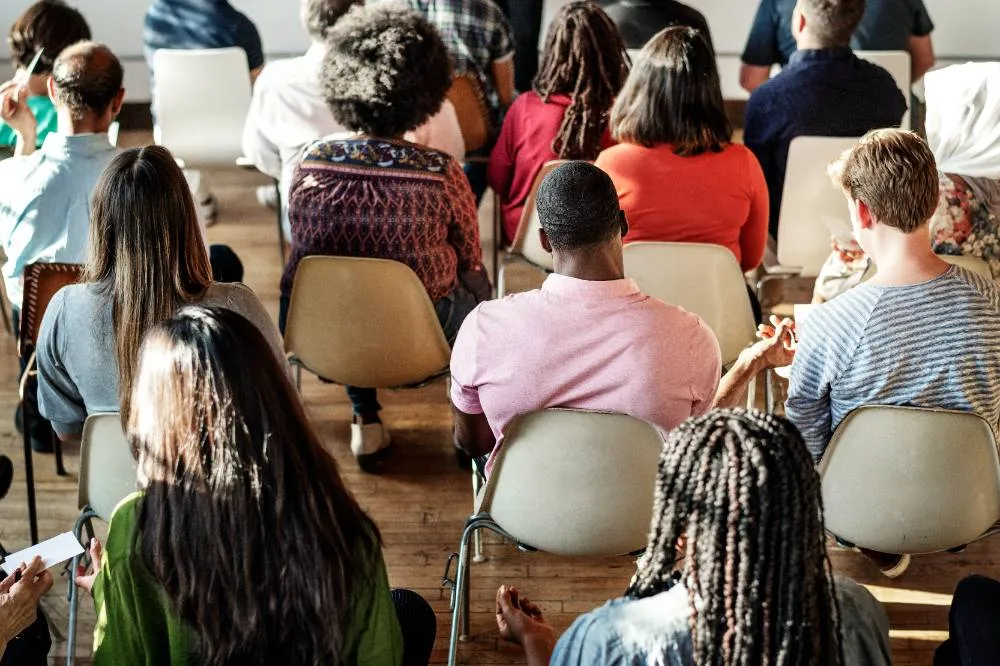 cheerful people sitting in seminar