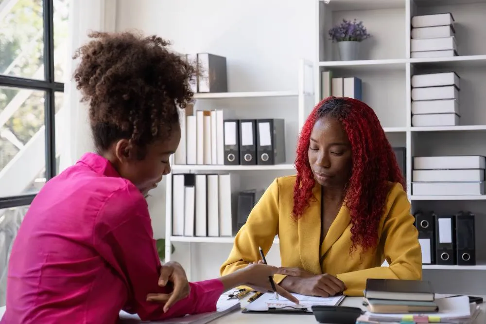 young african women talking in an office